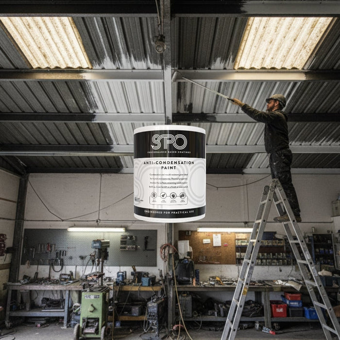 Person applying SPO Anti-Condensation Paint to the underside of a metal garage roof to stop condensation dripping